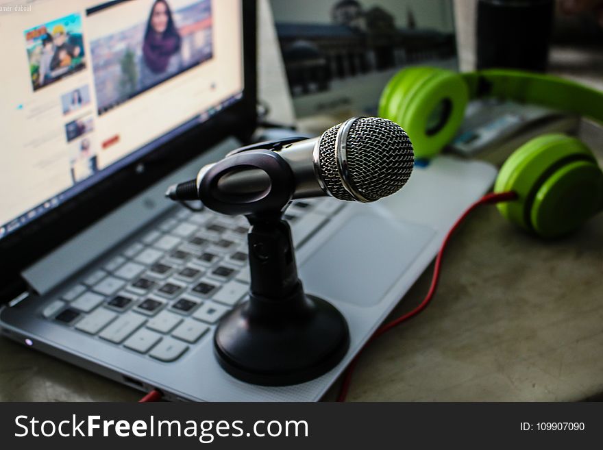 Green Headphones Near Laptop And Microphone