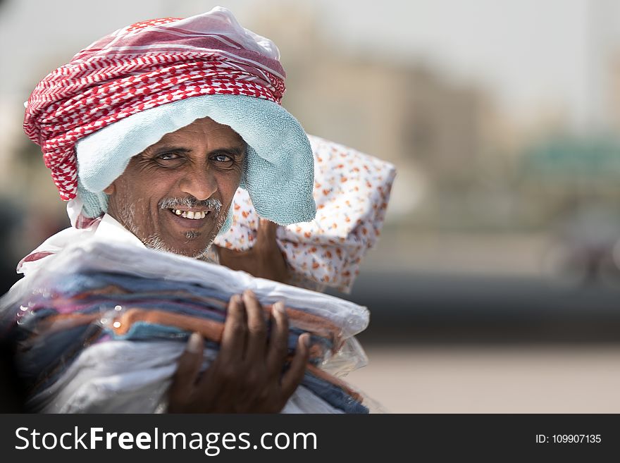 Man Holding Clothing While Smiling