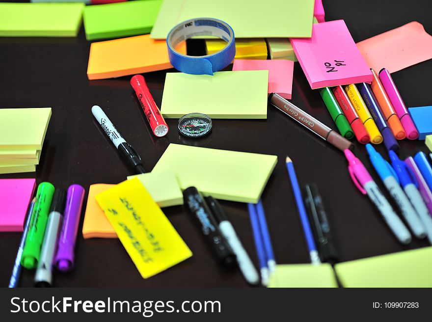 Photo of Sticky Notes and Colored Pens Scrambled on Table