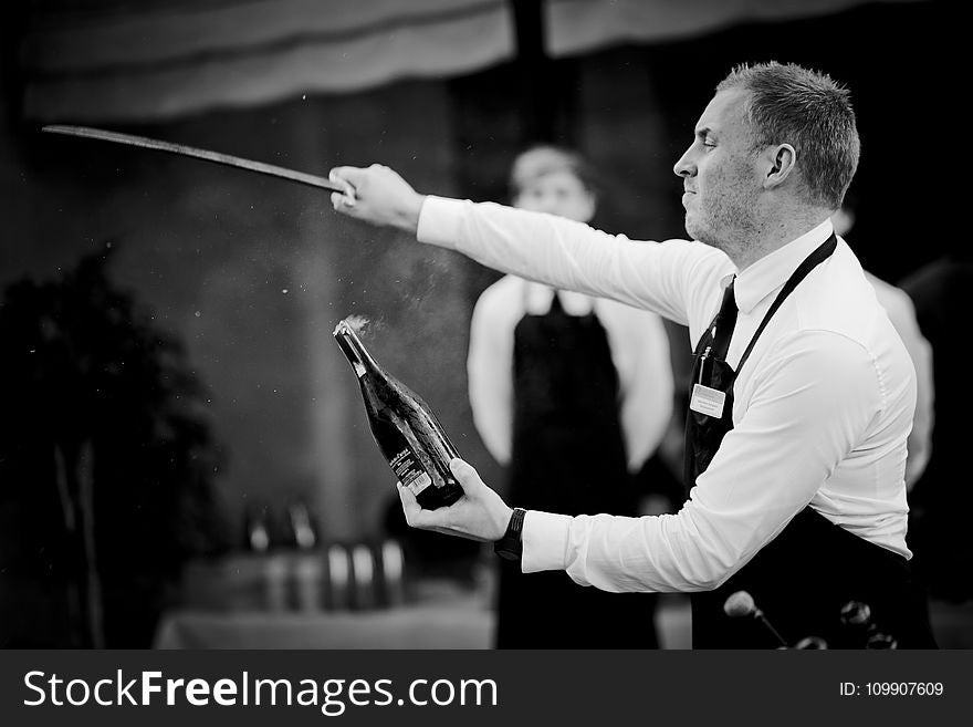 Grayscale Of Man Holding Sword And Bottle