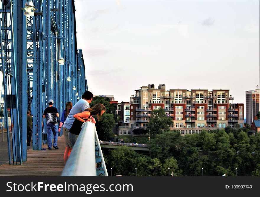 People Looking Down A Bridge
