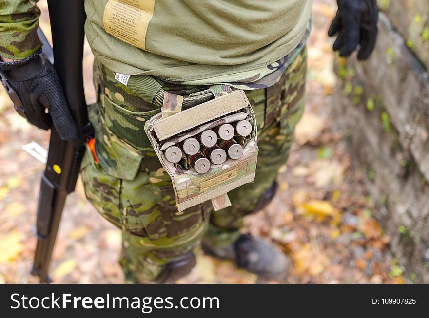 Person In Green Camouflage Print Pants Carrying Shotgun Shells