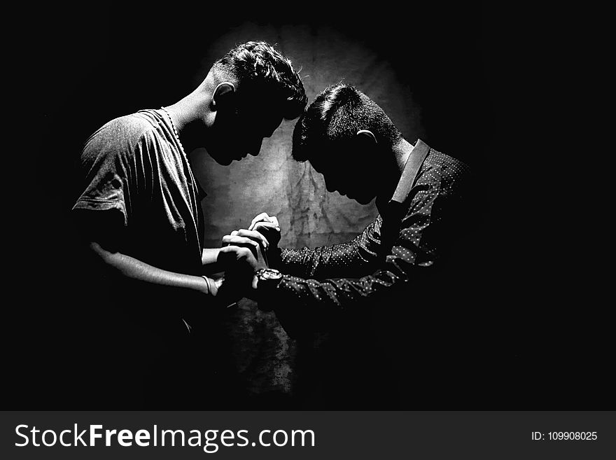 Grayscale Photo Of Two Men Holding Hands