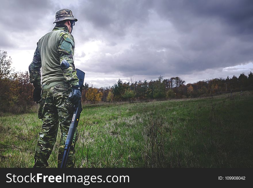 Man In Camouflage Soldier Suit While Holding Black Hunting Rifle