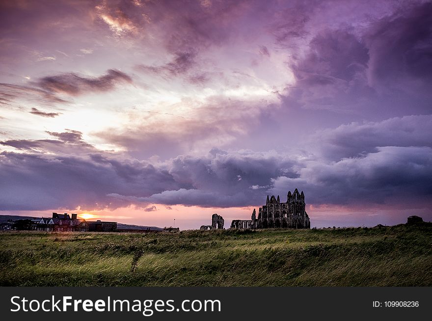 Green Field And White And Black Concrete Structure During Sunset