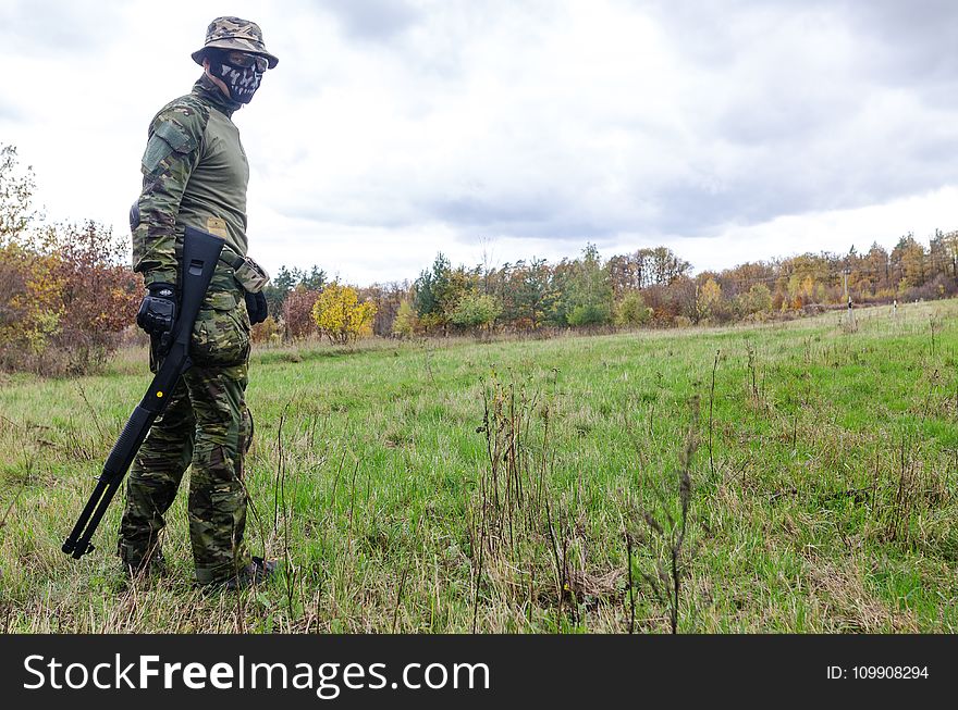 Photo of Man Wearing Green Combat Uniform Holding Rifle