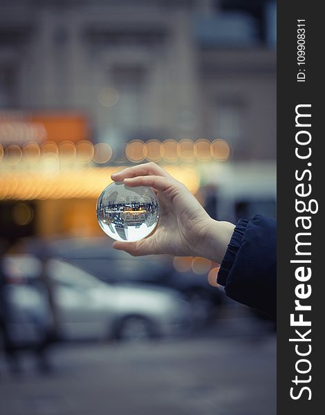 Person Holding Round Glass Ball Macro Shot