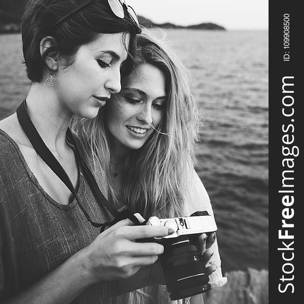 Grayscale Photo Of Two Women Looking At A Camera
