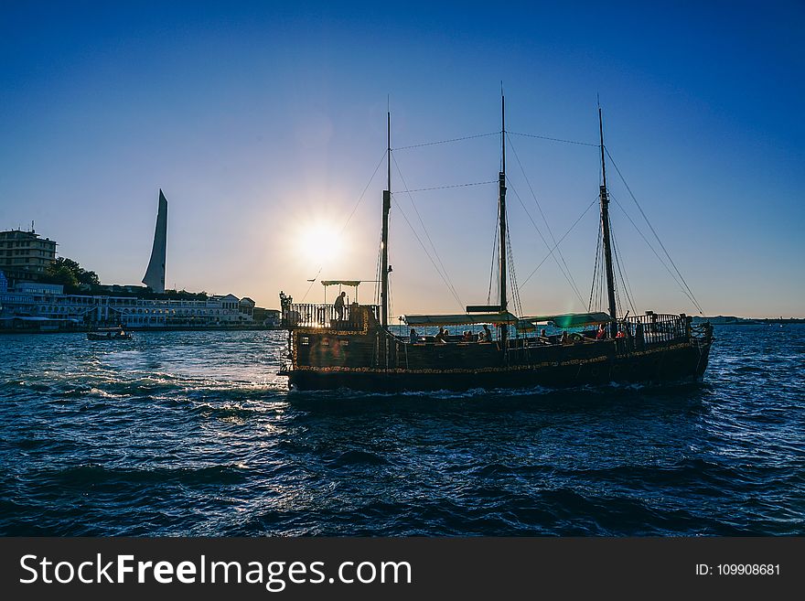 Green And Black Boat On Body Of Water During Sunrise