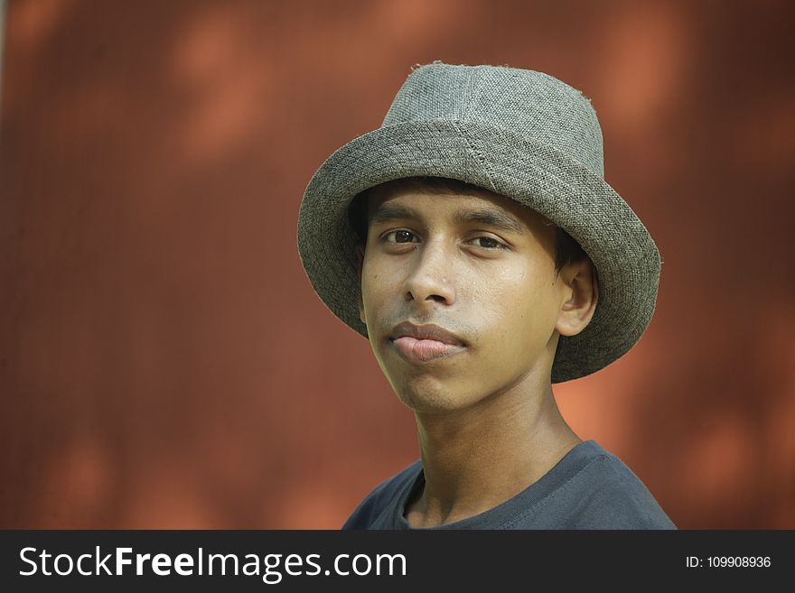 Selective Focus Photography of Man Wearing Gray Fedora Hat and Gray Crew-neck Shirt