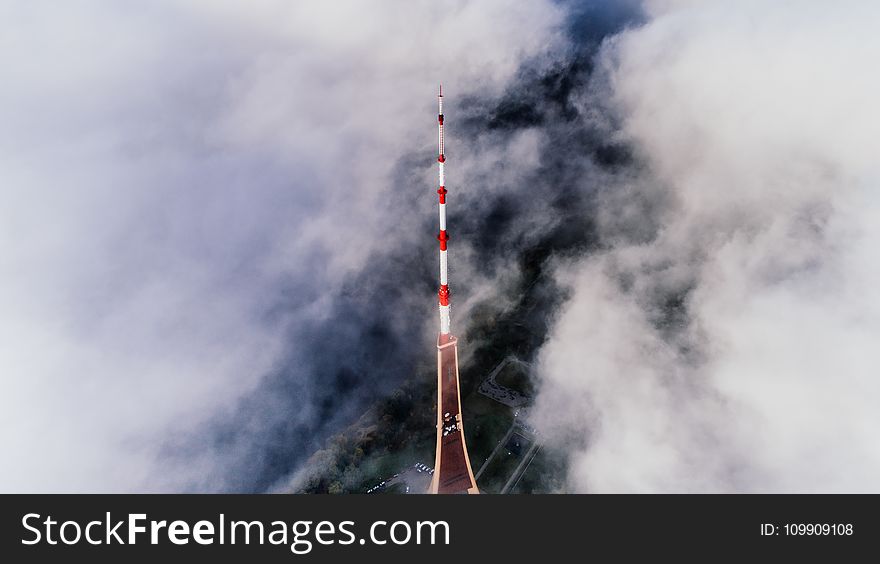 Aerial Photography Of Red And White Striped Tower Near Clouds