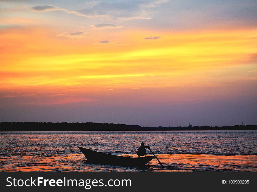 Silhouette Of Man On Boat In Water