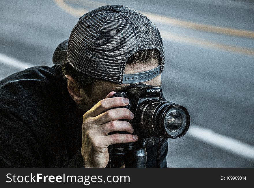 Man Taking Photo Using Black Canon DSLR Camera