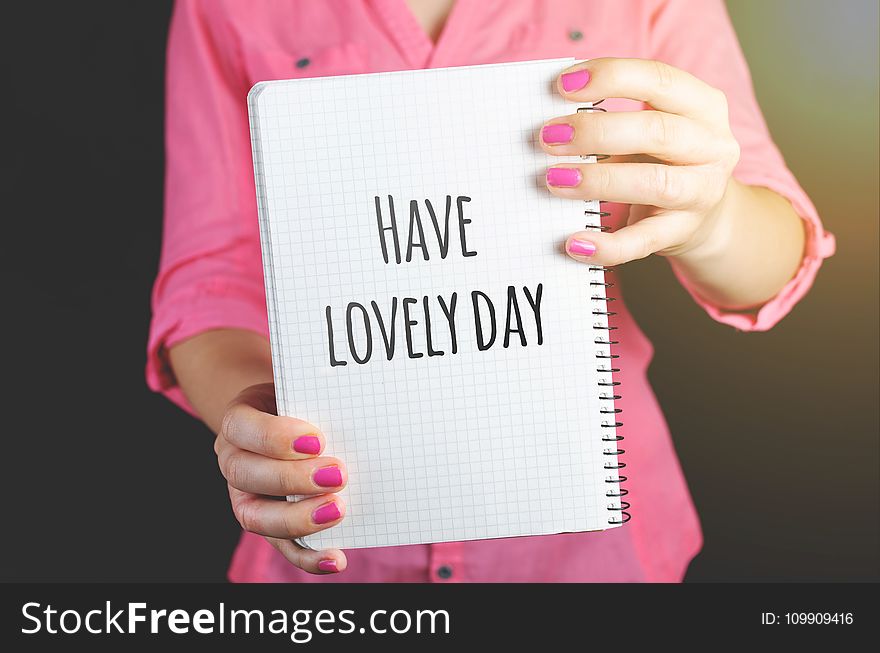 Woman Wearing Pink Dress Holding Graphing Notebook With Have a Lovely Day Sign
