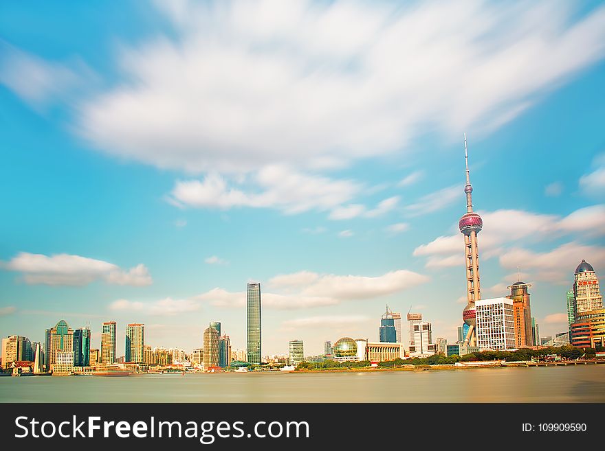 Pearl Tower Near Body of Water Under Clouds Photo Taken