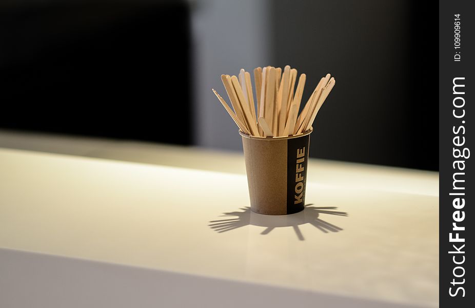 Brown Popsicle Sticks in Brown Disposable Cup