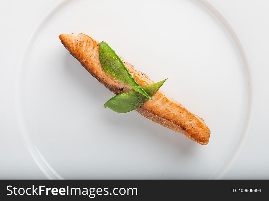 Cooked Fish With Two Green Leaf on Round White Ceramic Plate