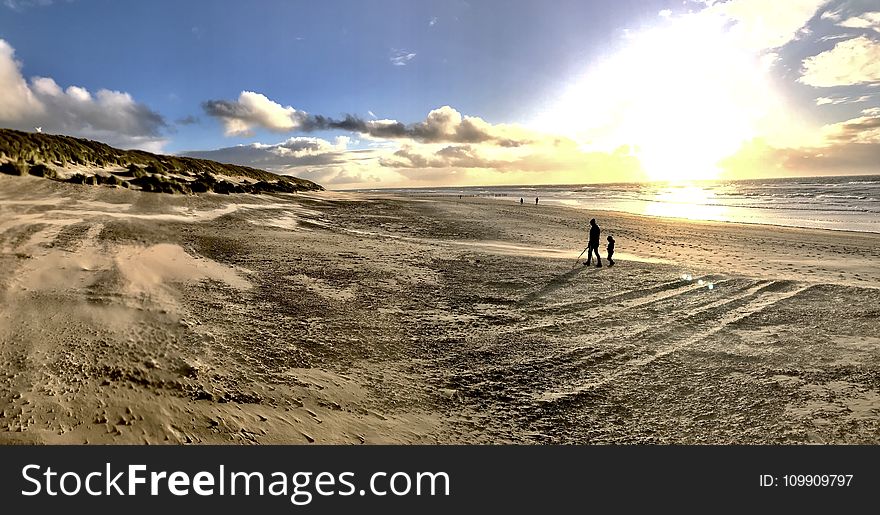 Photo of People Walking on Brown Sand