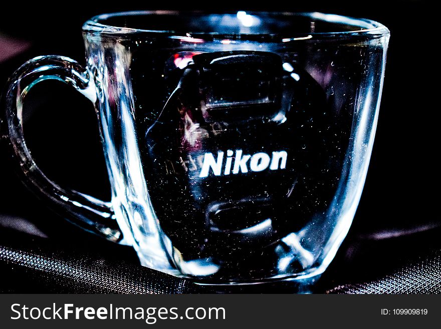 Close Up Photo Of Clear Glass Mug With Nikon Lens Cap