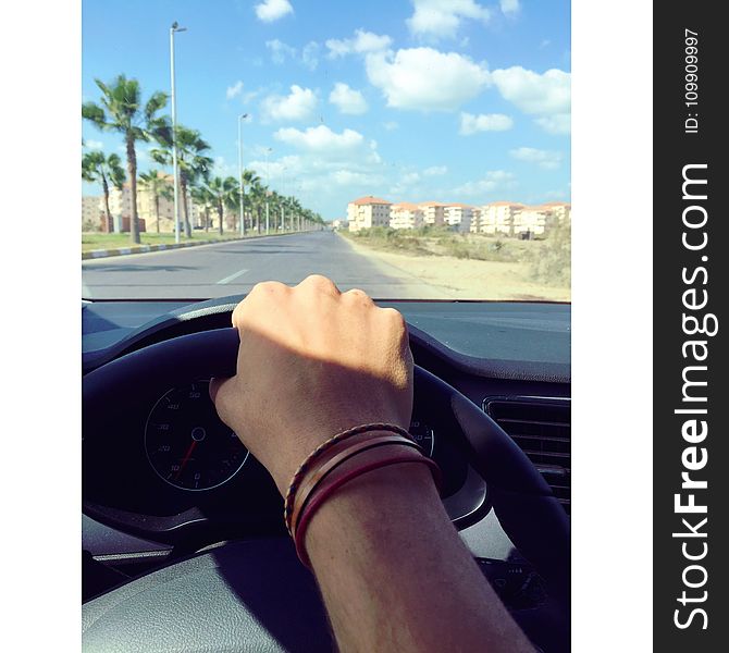 Person Withe Bracelets Holding Black Steering Wheel