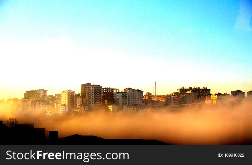 Photography of Buildings on a Foggy Morning