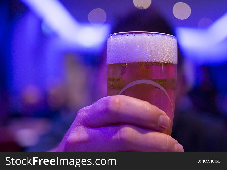 Person Holding Shot Glass Filled With Beer