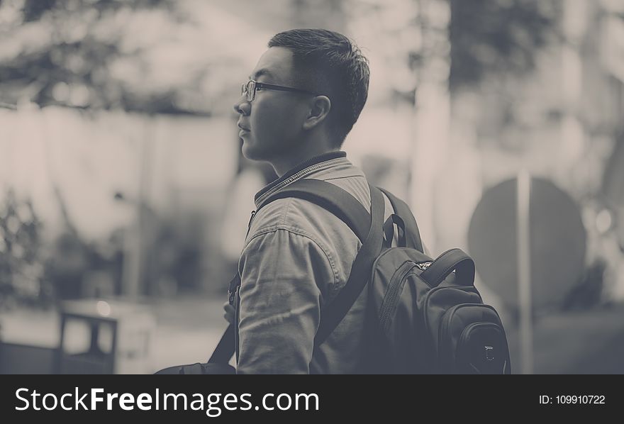 Grayscale Photo of Man Wearing Backpack