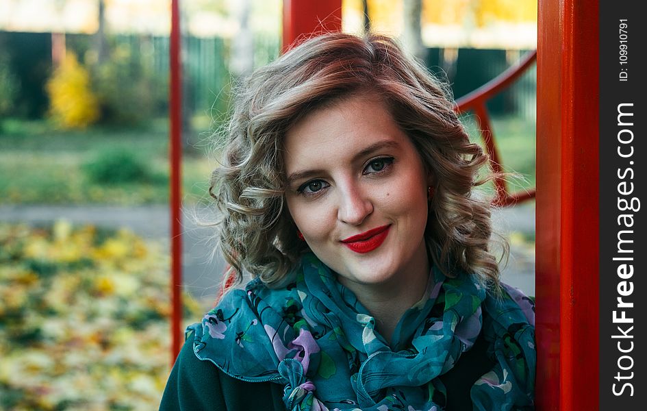 Woman Wearing Blue and Purple Floral Print Scarf Taking a Selfie