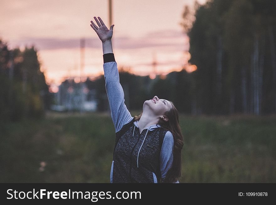 Woman In Gray And Black Zip-up Hoodie Raising Her Right Hand