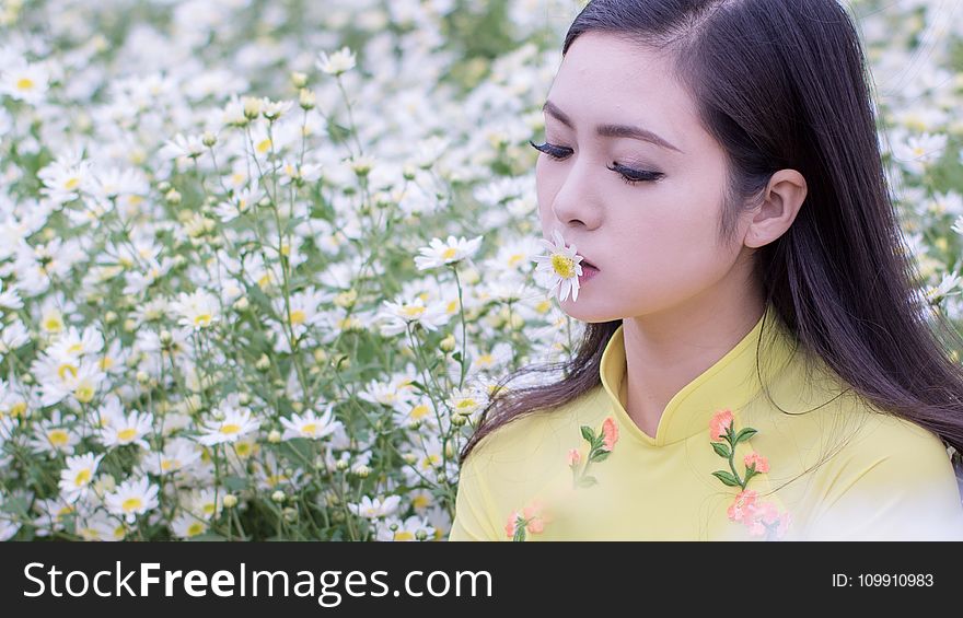 Selective Focus Photography of Woman Kissing White Petaled Flower
