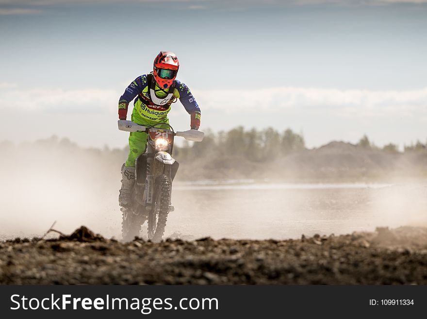 Person In Green Motocross Gear Riding A Dirt Bike