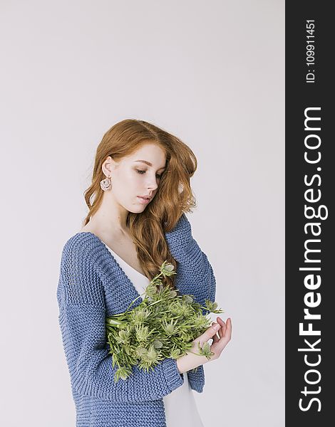 Woman in Blue Cardigan Holding Green Flowers