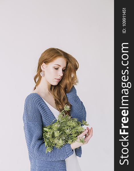 Woman In Blue Cardigan Holding Green Flowers