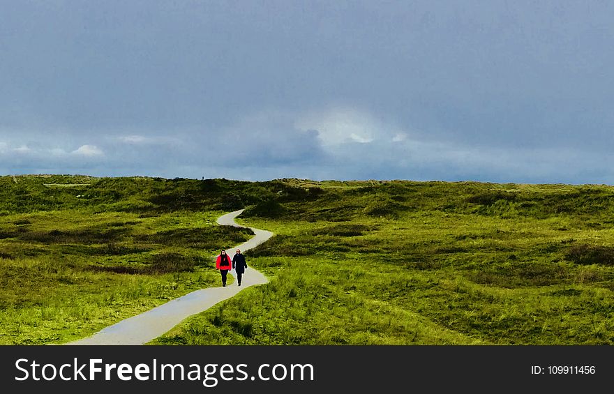 Two Person Walking On Path Under Blue Sky