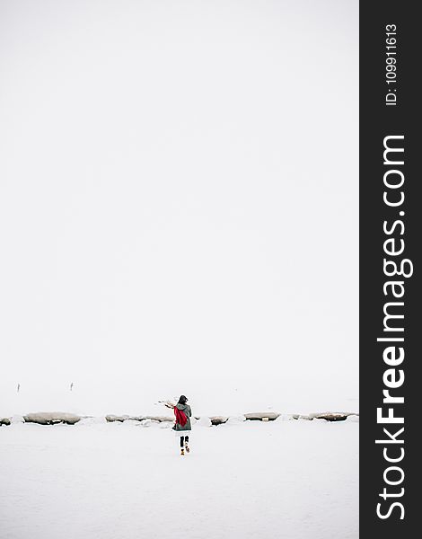 Woman Walking On Snow-covered Field