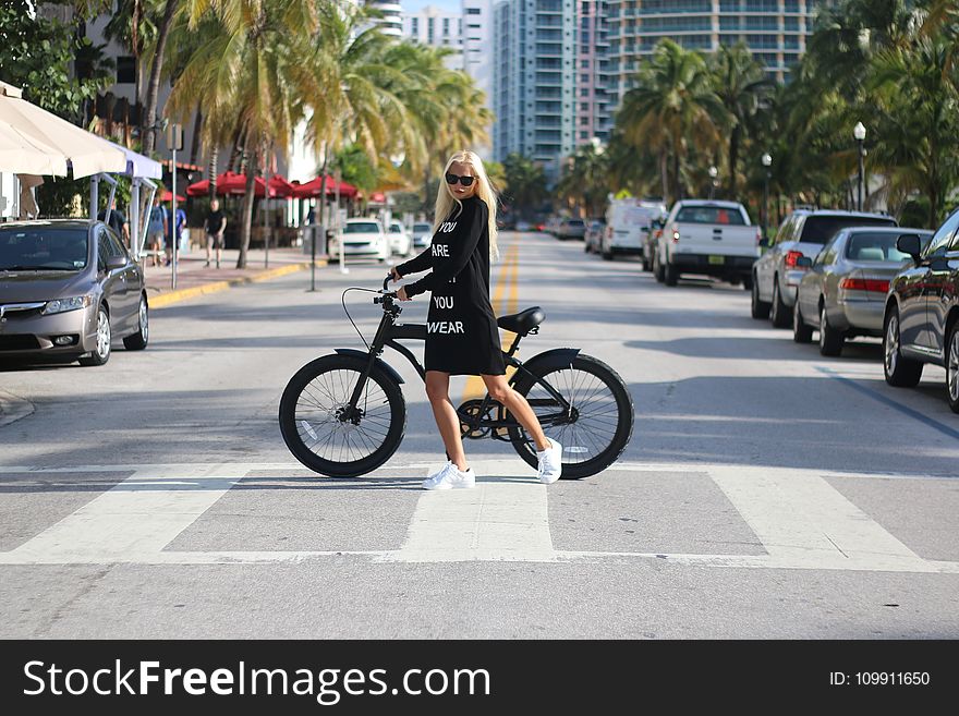 Woman In Black Long Sleeve Shirt Holding Bicycle