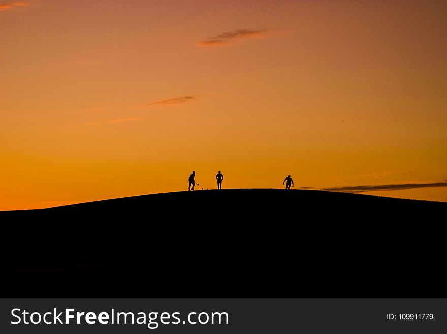 Silhouette of 3 People in Hill during Sunset