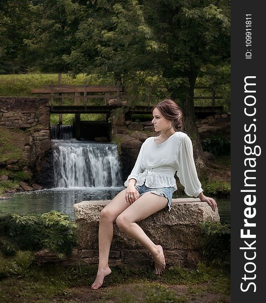 Woman Wearing White Long Sleeve Shirt Sitting Near Waterfalls