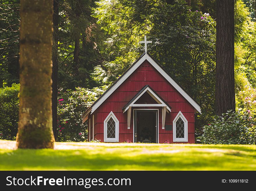 Red Chapel on Grassy Field With Trees