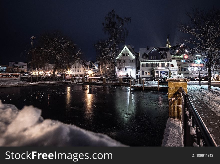 Body of Water Infront of White 3-storey Houses during Night Time