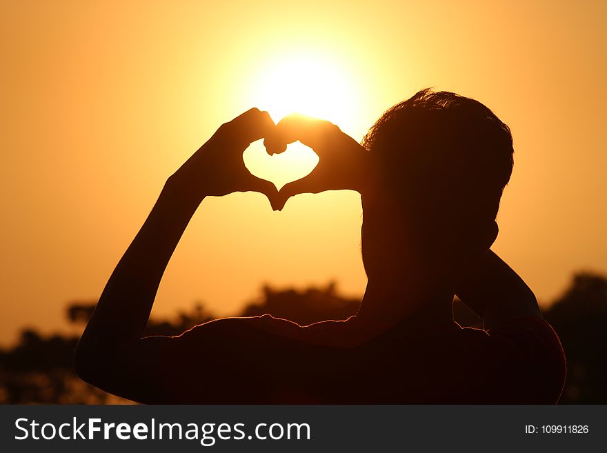 Silhouette Photo Of Man Doing Heart Sign During Golden Hour