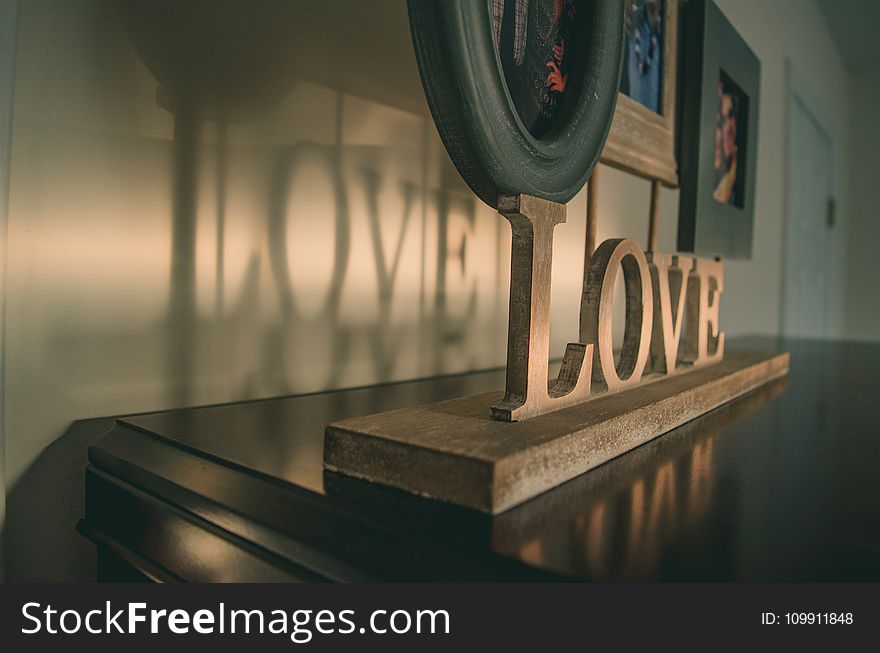 Brown Wooden Love Free Standing Letter on Black Wooden Surface