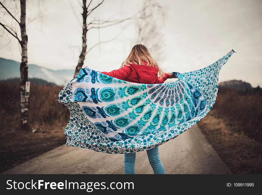 Woman Standing on the Middle of the Road Holding Blanket