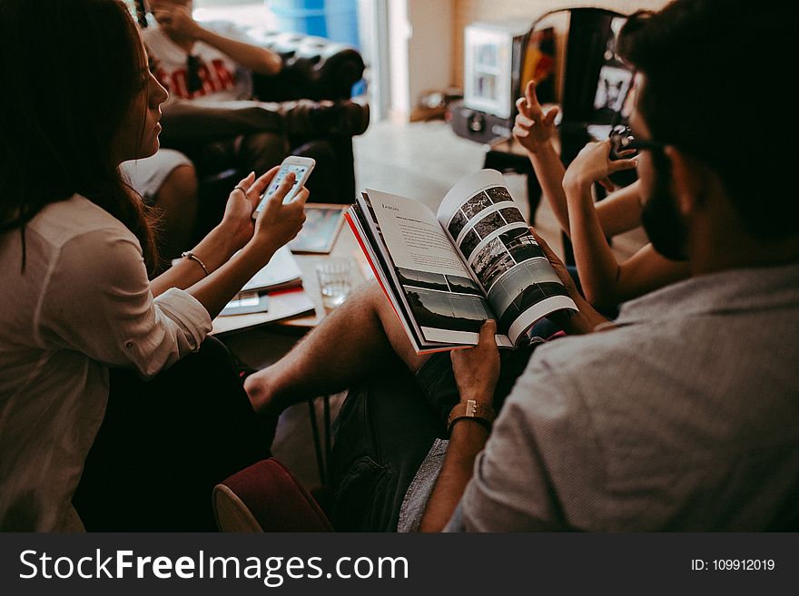 Group of People Reading Book Sitting On Chair