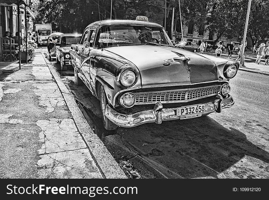 Grayscale Photography of Vintage Car Beside Pavement