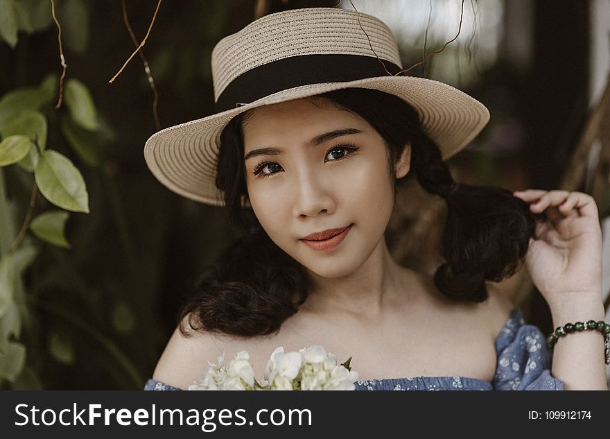 Focus Photography of Woman in Brown Sunhat Near Vine Plant