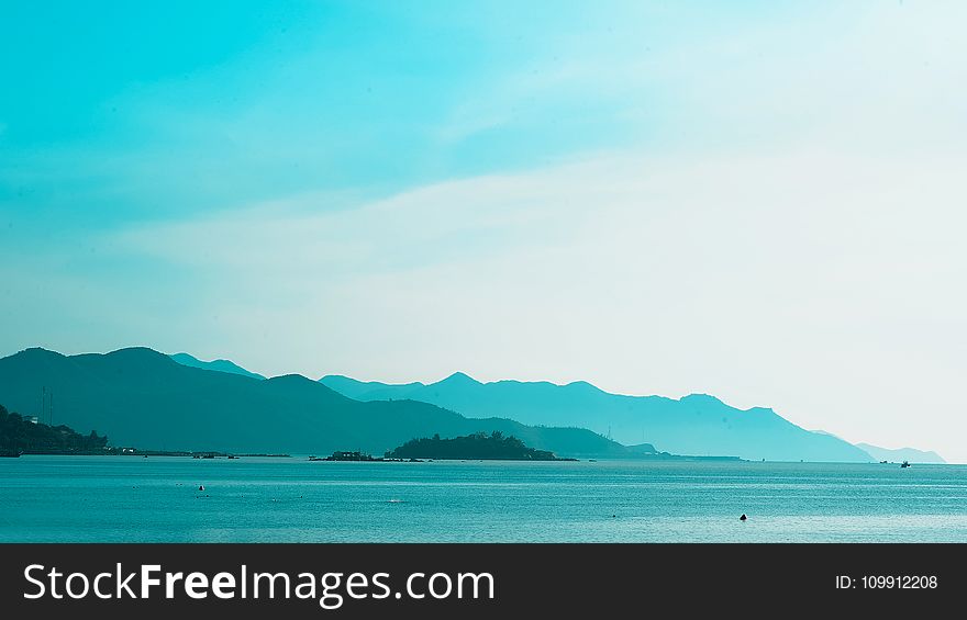 Silhouette Of Mountain Near The Body Of Water Photo In Daytime