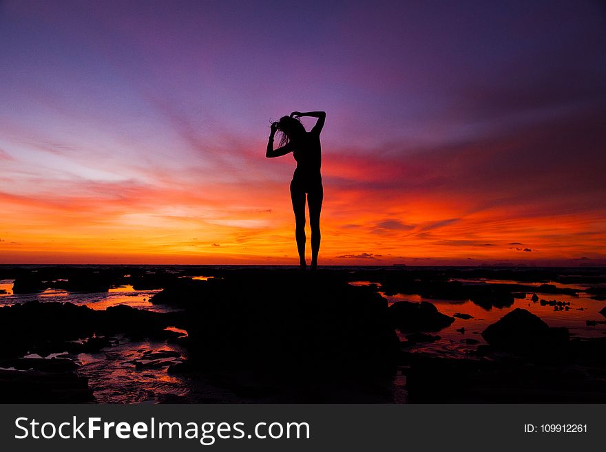 Silhouette of Woman Standing on Rock