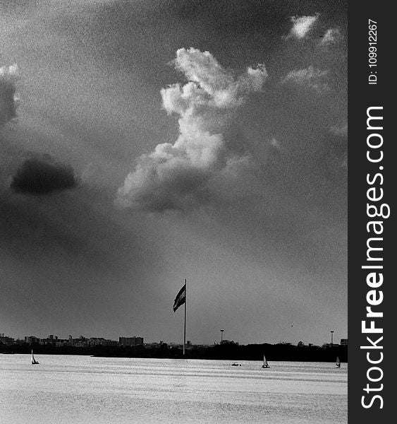 Grayscale Photo Of Flag And Clouds