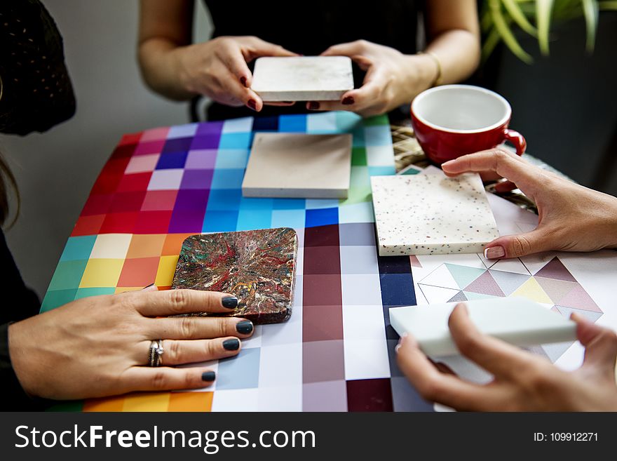 Shallow Focus Photography of Three People Holding Square Panels